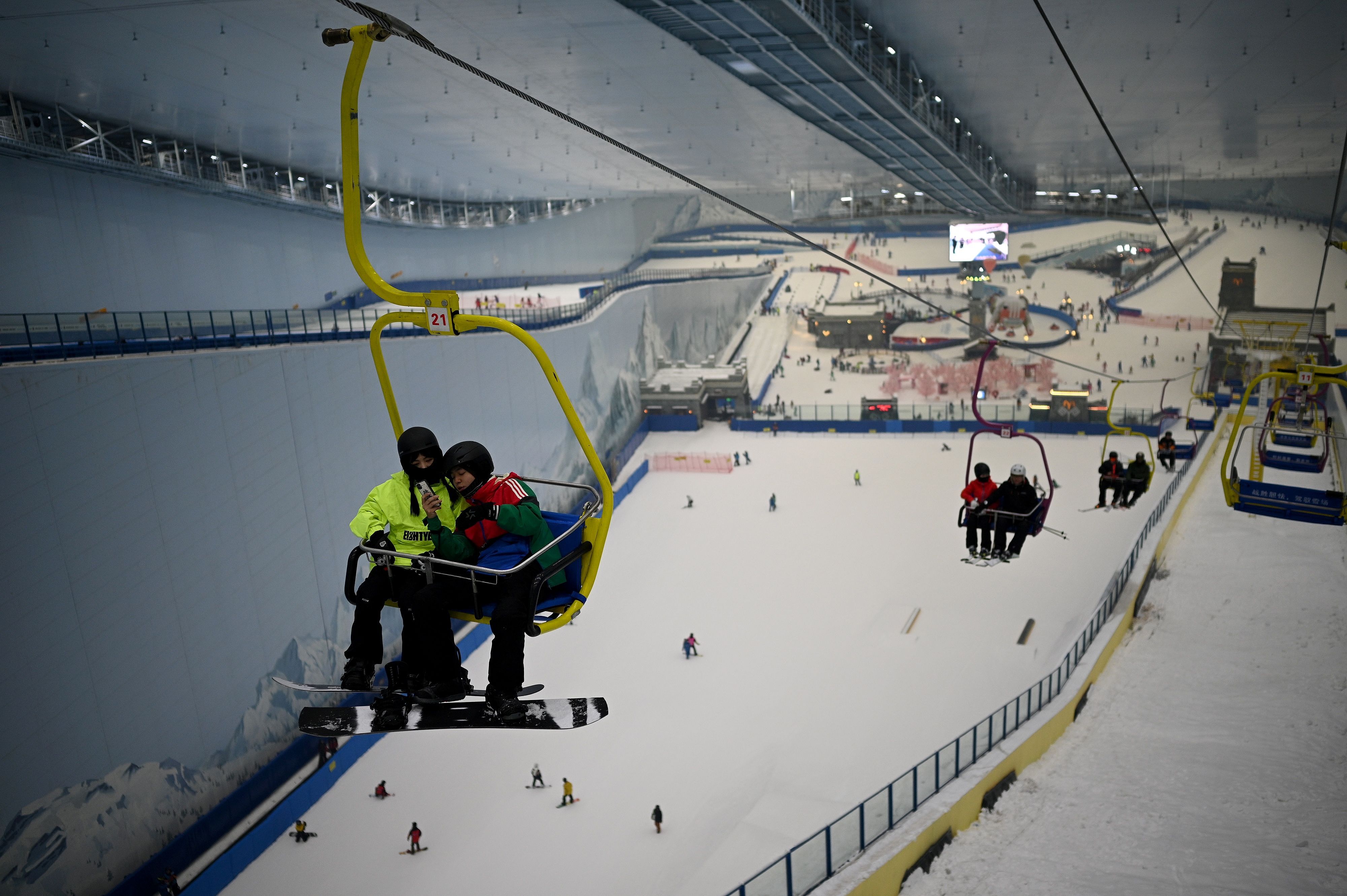 四川成都，融创雪世界内，人们在室内滑雪胜地乘坐滑雪缆车。.jpg