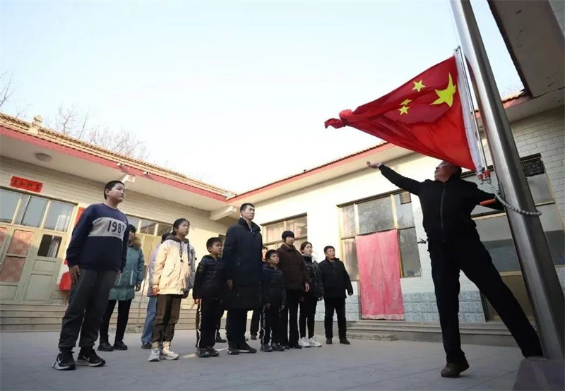 张自轩和父亲及家人一起在家中升国旗"护卫国旗 重于生命"深深烙印在