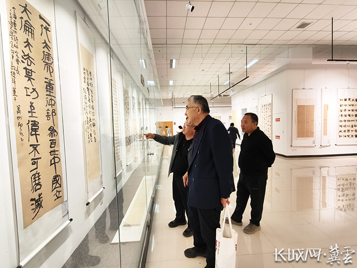 观众观摩书法作品的结构布局。